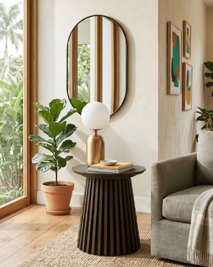 Espacio decorado con espejo redondo, mesa auxiliar y lámpara